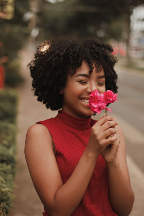 Free Smiling woman enjoying bougainvillea flowers outdoors, showcasing natural beauty and happiness. Stock Photo