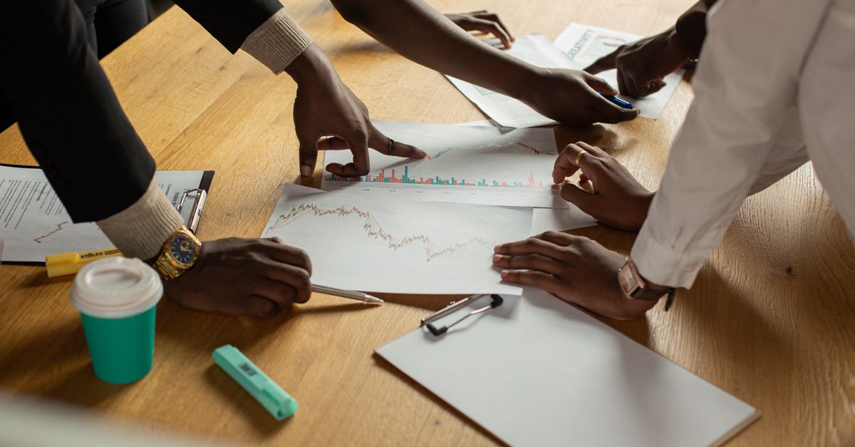 A diverse team collaborates on analyzing data charts during a meeting.