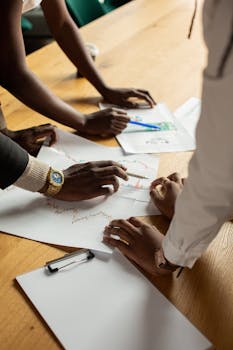 A diverse group discusses business documents in an office environment.