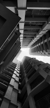 Black and white perspective of tall modern buildings from below.