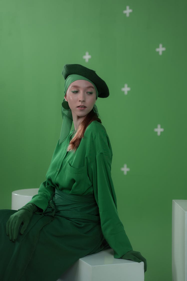 A Woman In A Green Outfit Sitting