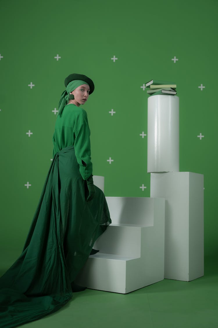 A Woman In A Green Outfit Going Up A Stairs