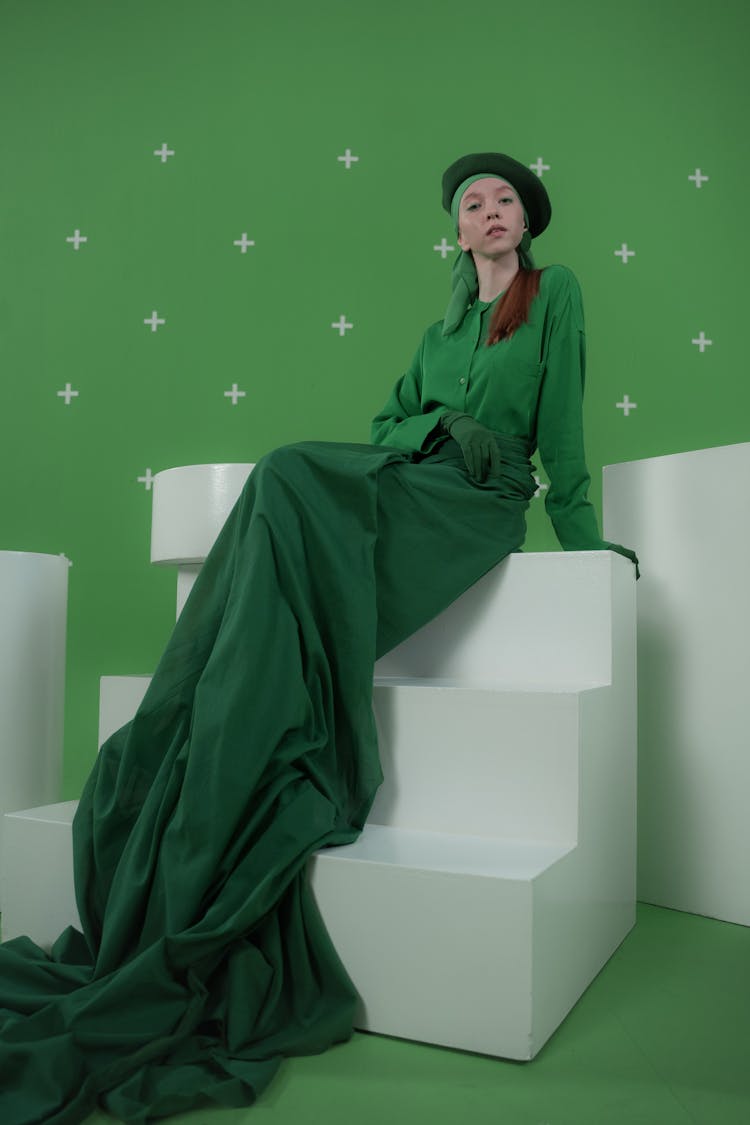 
A Woman In A Green Outfit Sitting On Stairs