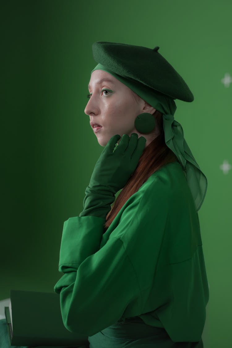 A Woman In Green Outfit Holding A Book