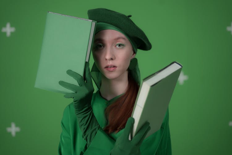 A Woman In A Green Outfit Holding Books