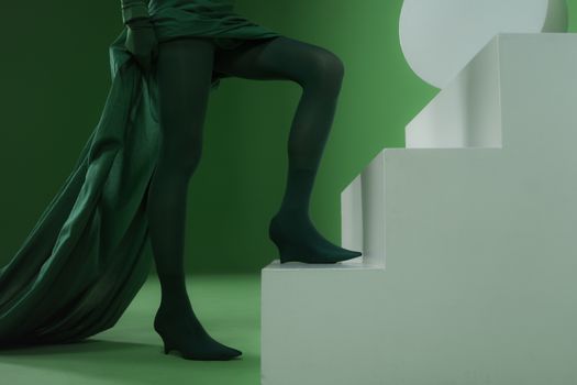 Chic and stylish monochrome green fashion ensemble on modern stair setting. Perfect for vogue and style themes.