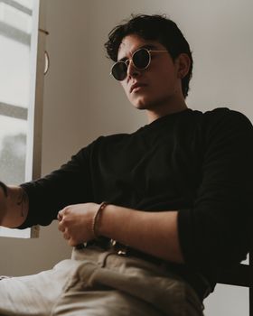 A Man Wearing a Black Sweater and Sunglasses