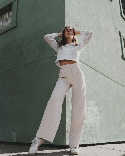 Low angle view of a fashionable woman posing dramatically in urban setting.