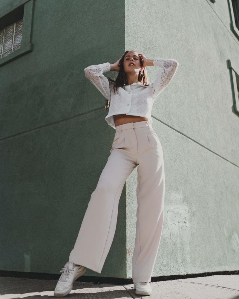 Woman wearing white long sleeved shirt and wide leg pants