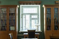 Inviting library space featuring wooden cabinets, books, and a window view.