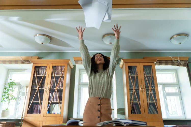 Photograph Of A Girl Throwing Sheets Of Paper