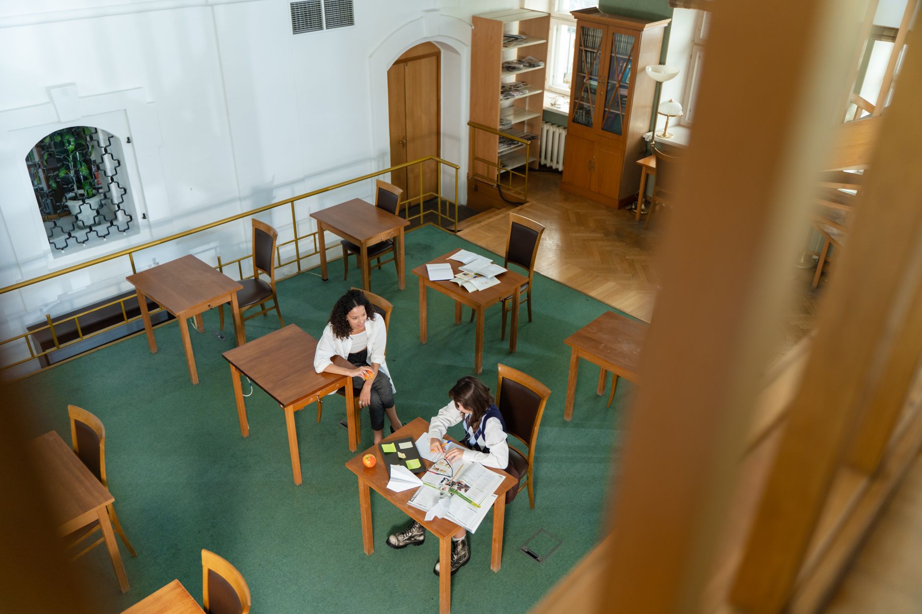 Student studying in an elegant international school library with a globe and architectural light