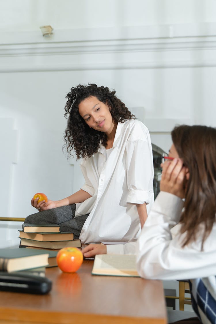 Photo Of A Girl With Curly Hair Talking To Her Friend