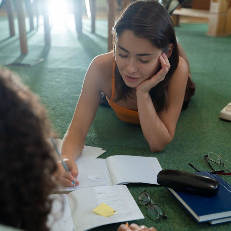 Photograph Of A Girl Writing With A Pencil