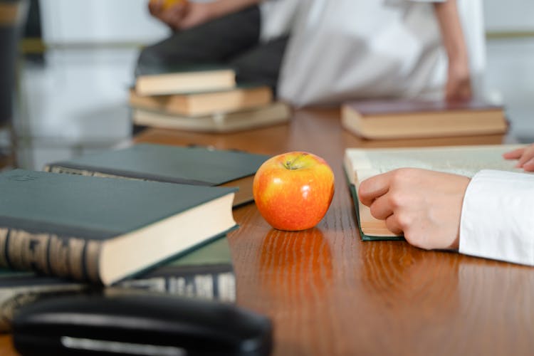 Apple And Books On Wooden Table 