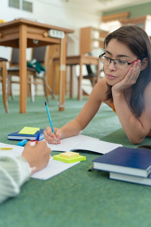 A Woman Studying while Lying on the Floor