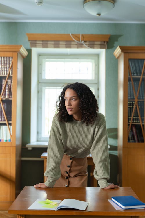 Free Woman Wearing Sweater inside the Library Stock Photo