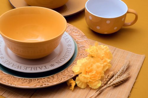 Free An elegant yellow-themed tableware setting with ceramic bowls and flowers. Stock Photo