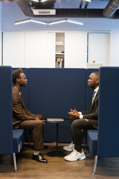 Two professionals in a modern office setting discussing business strategies.