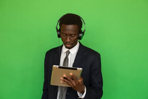 Free Man in Black Suit Holding Looking at a Tablet Computer Stock Photo