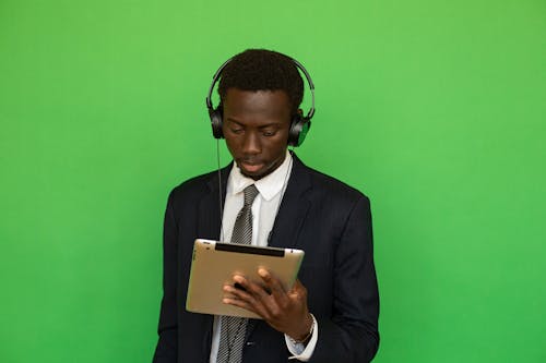 Man in Black Suit Holding Looking at a Tablet Computer