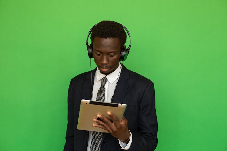 Man In Black Suit Holding Looking At A Tablet Computer