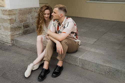 Hombre y mujer libres sentados en un banco de concreto Foto de archivo