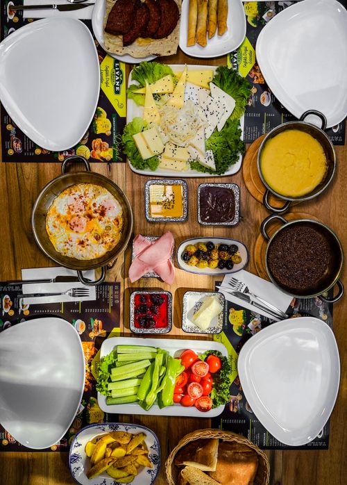 Free A diverse and colorful spread of fresh foods and dishes presented in a flat lay arrangement on a wooden table. Stock Photo