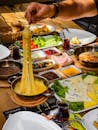 A Person Getting Melted Cheese from a Pan