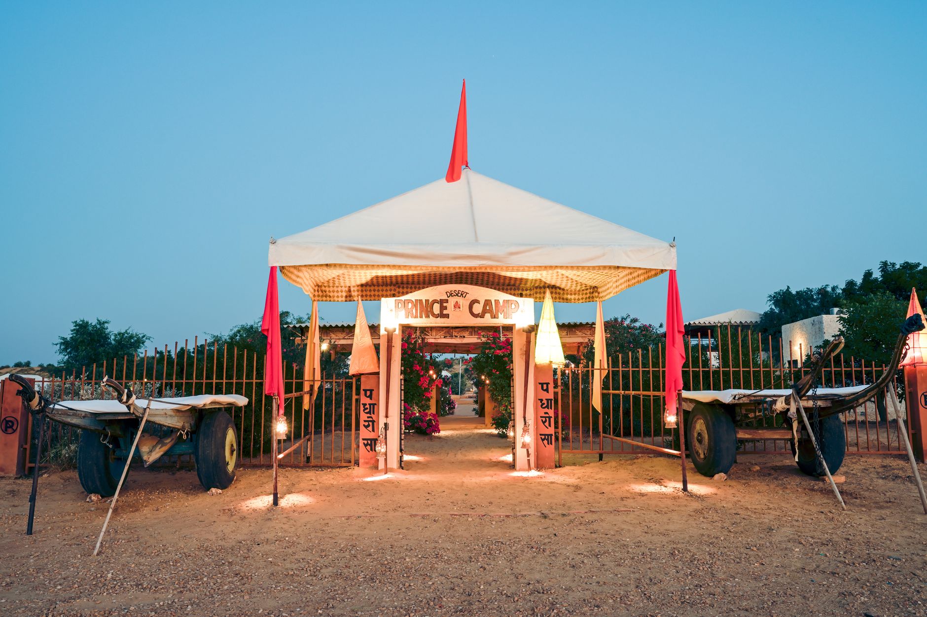 Scenic entrance of Prince Desert Camp with traditional carts in Jaisalmer, India during twilight.