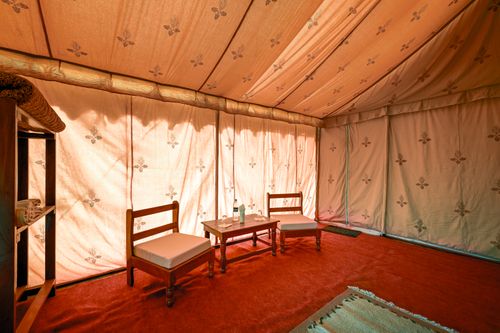 Free Inviting tent interior in Jaisalmer, India featuring chairs, a table, and a cozy ambiance. Stock Photo