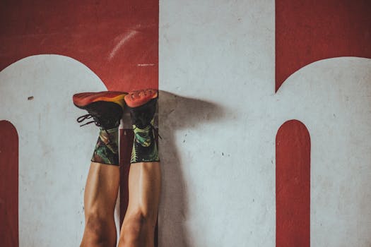 穿着五颜六色的袜子和运动鞋的人正在大胆的红色墙壁前锻炼