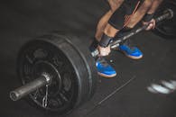 一名男子在健身房用沉重的杠铃做硬拉，展示力量和健身成果