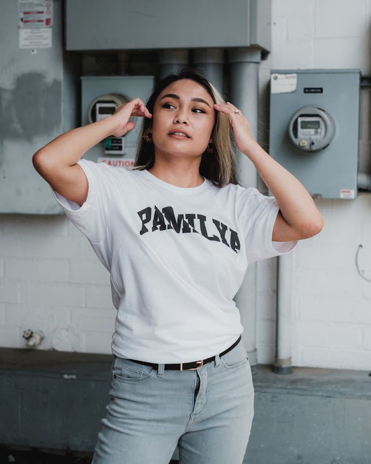 Young Woman In Casual Clothing Fixing Hair 