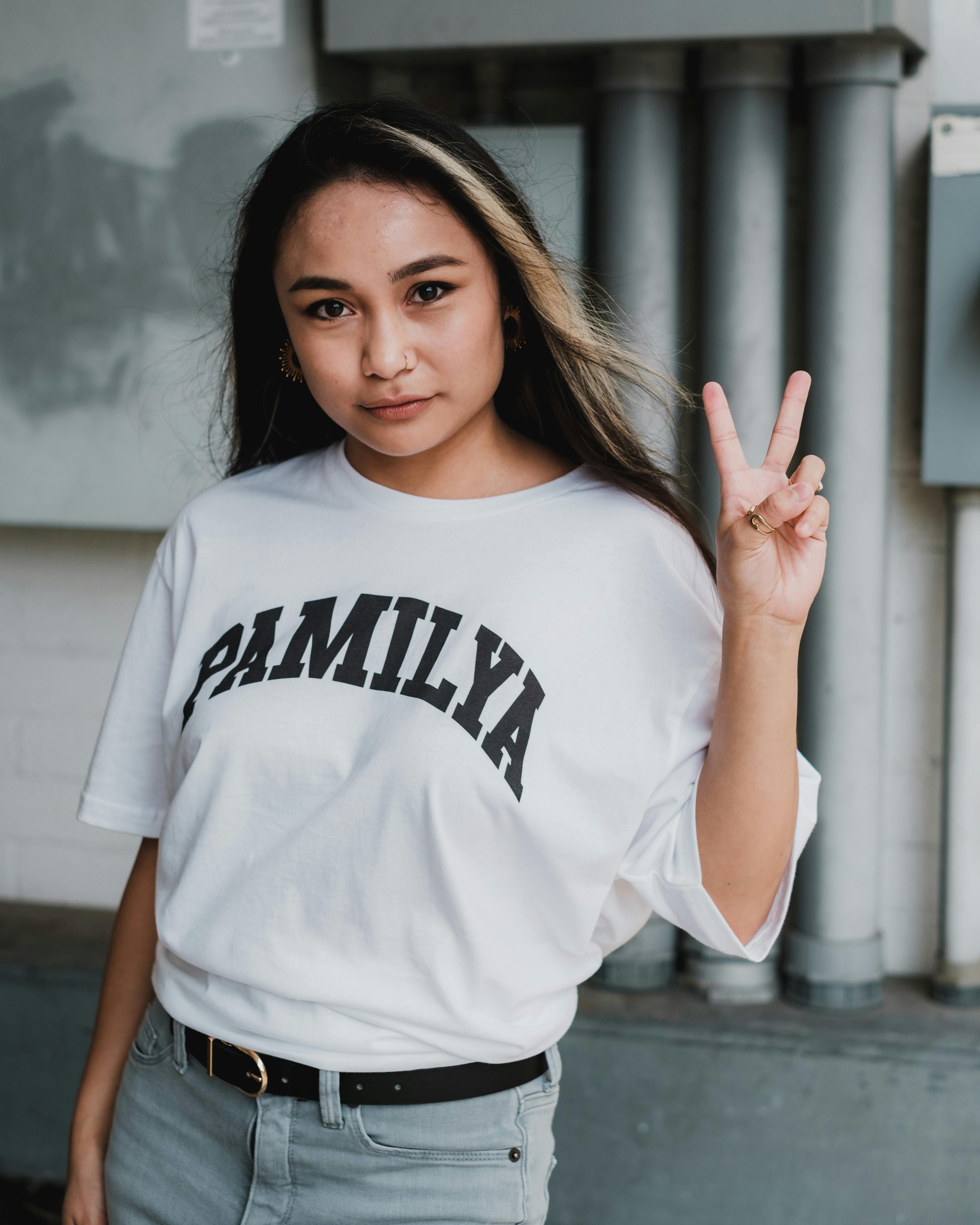 young woman with long hair showing sign of v