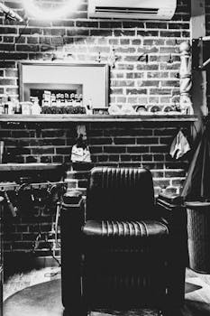 Black and white image of an old-fashioned barber shop featuring a vintage leather chair.