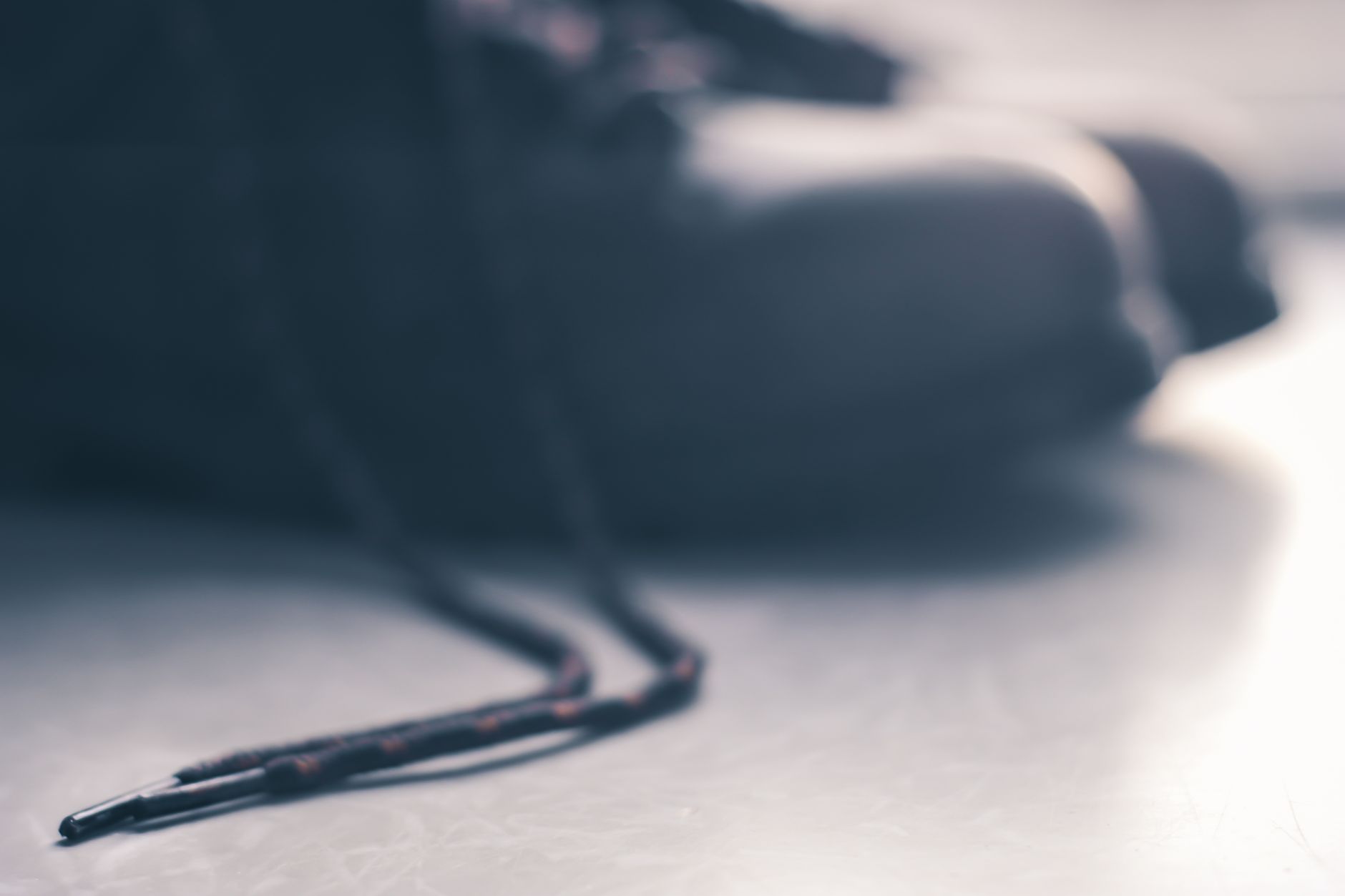 A blurred image of a shoelace and part of a shoe, creating a dynamic and abstract effect.