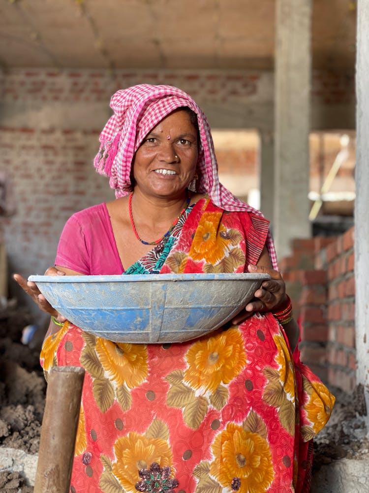 Smiling Adult Woman In Traditional Clothing Carrying Big Bowl