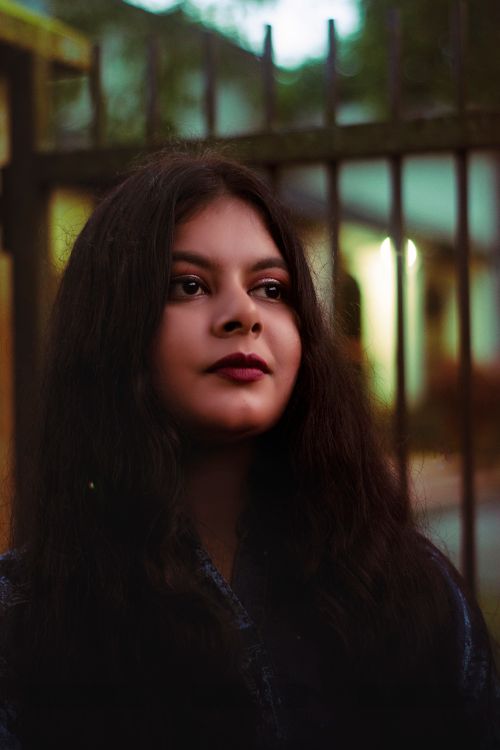 Free Portrait of a woman with long hair in an outdoor setting with soft lighting at dusk. Stock Photo
