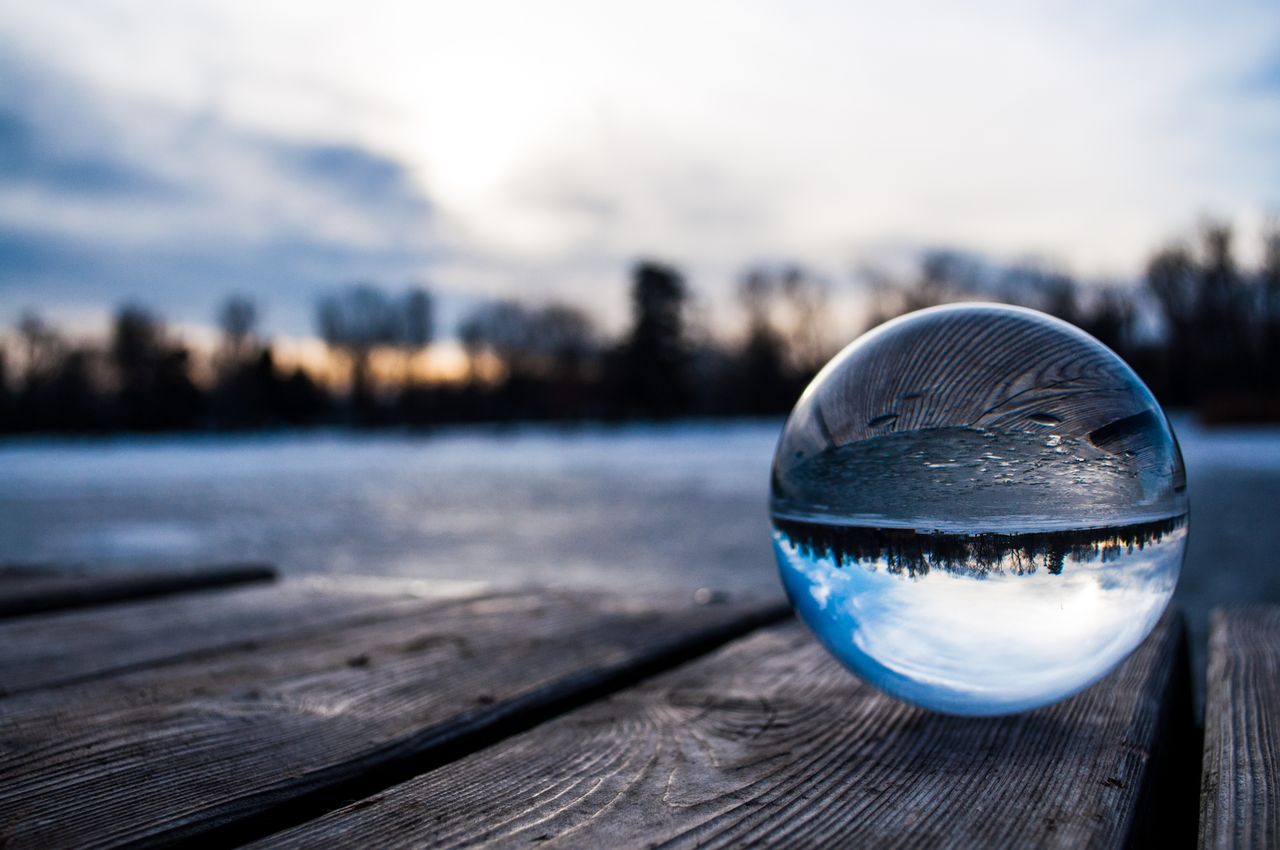 a serene reflection of a winter sunset captured in a glass sphere on a