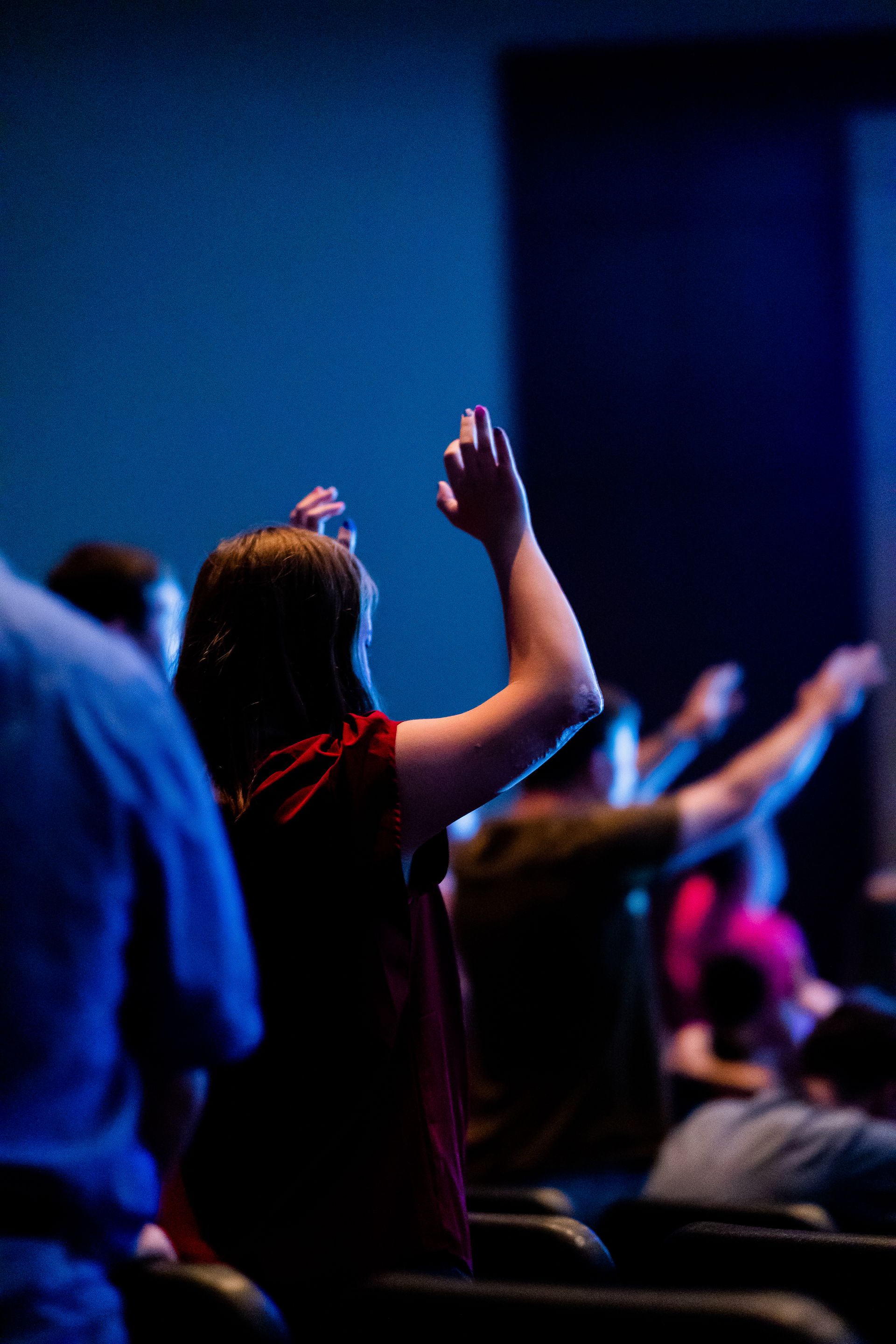 The congregation gathered under blue stage light for the Sunday message