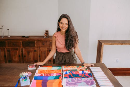 Young Woman Standing Next to a Table with Colourful Fabric Samples 