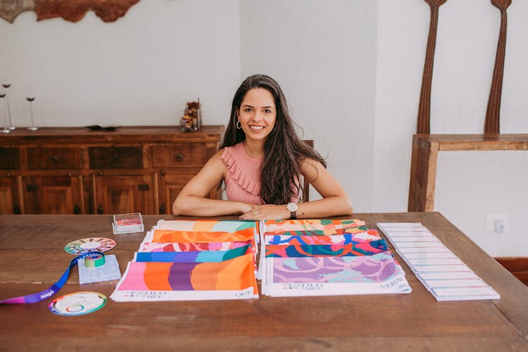 Woman Sitting At The Table With Fabric Samples 