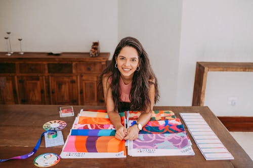 Smiling Woman with Colorful Fabrics on Table