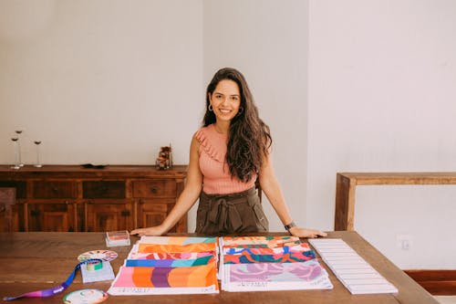 Young Woman Standing Next to a Table with Colourful Fabric Samples 