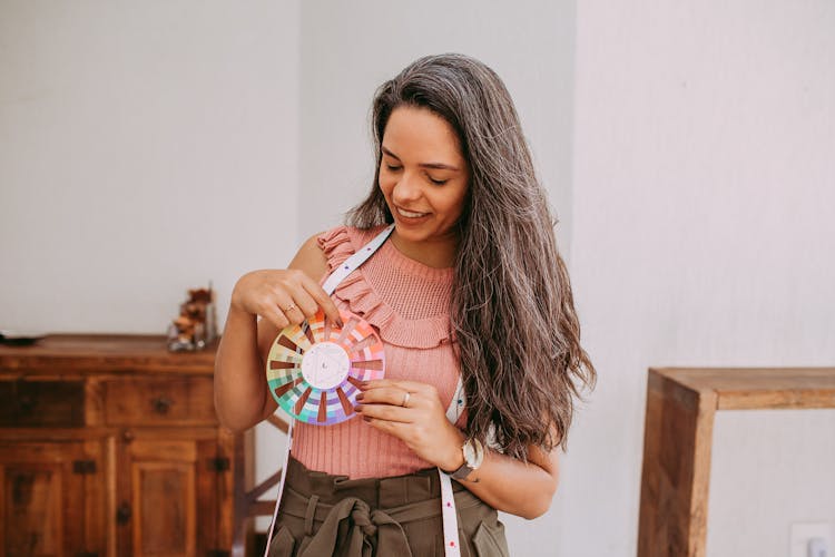 Woman Holding Colour Samples On A Palette And Smiling 