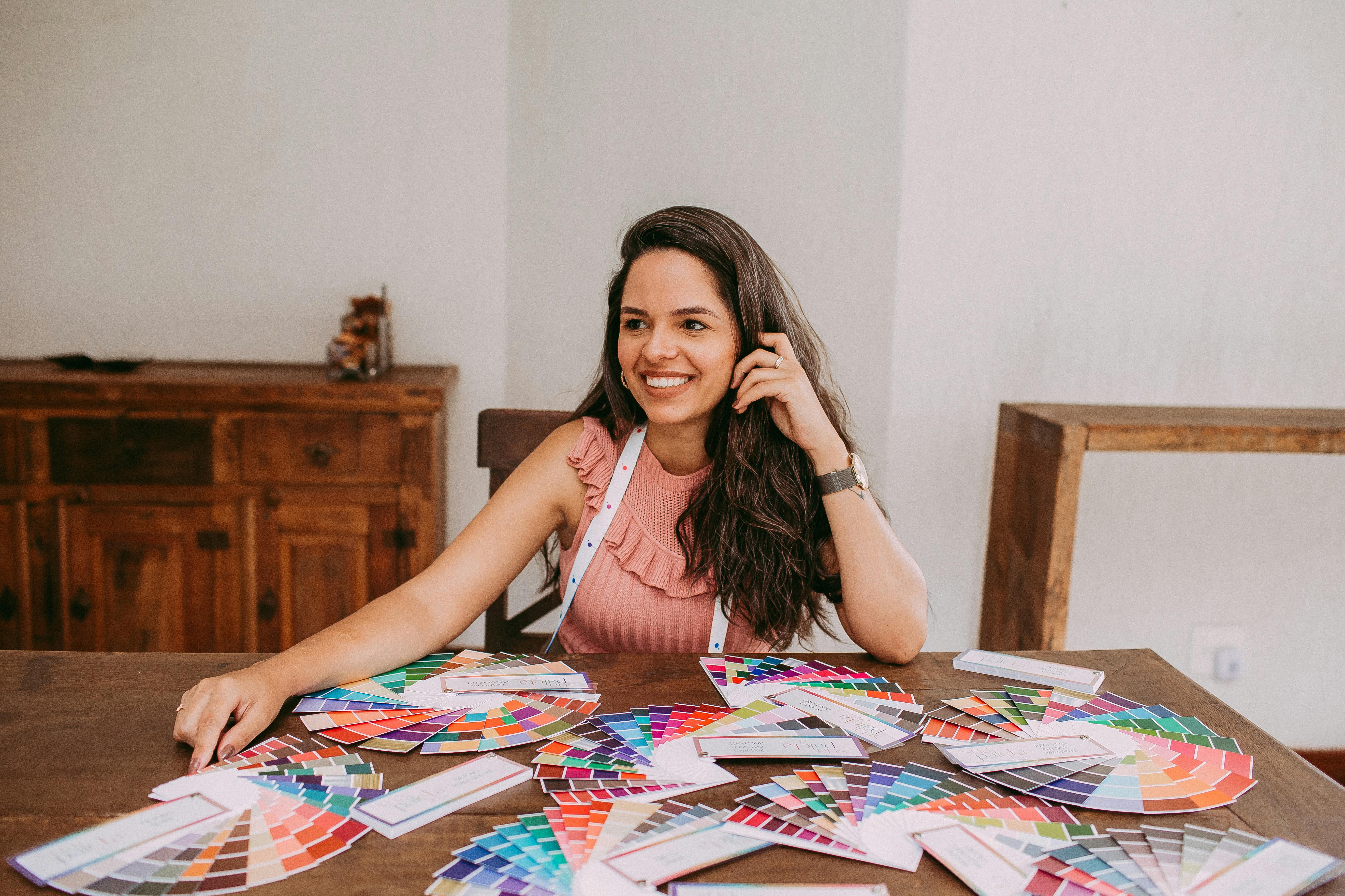 Smiling Woman Sitting at Desk with Color Samples