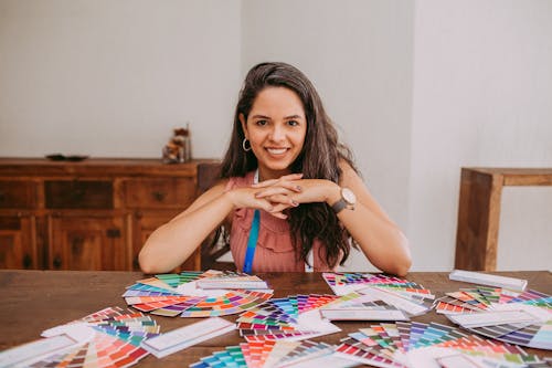 Smiling Woman Sitting at Desk with Color Palettes