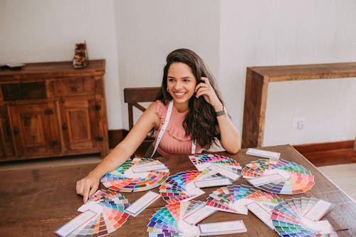 A Woman Sitting at a Wooden Table with Color Palette Samples
