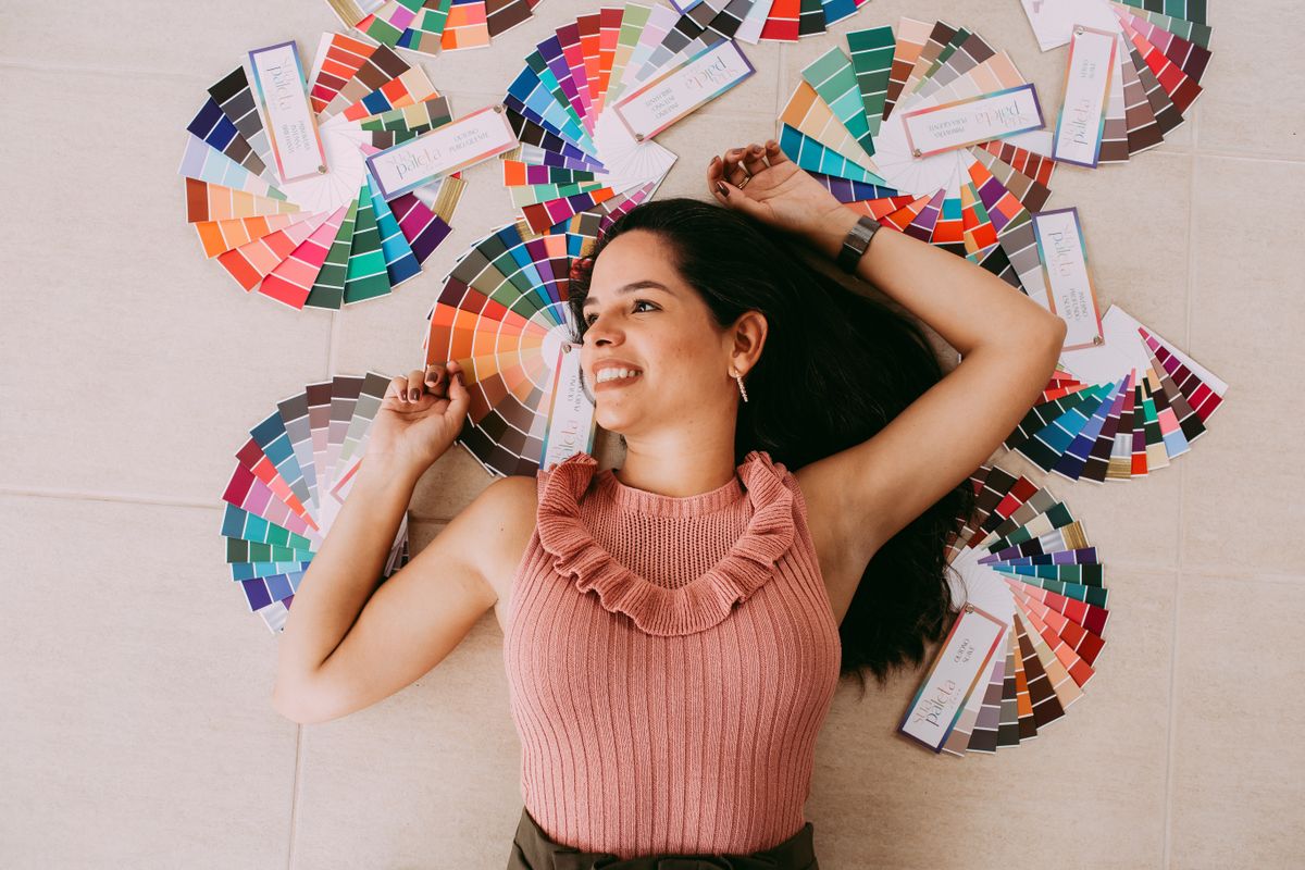 Juniper Okafor, visual designer, smiling among colour swatch fans